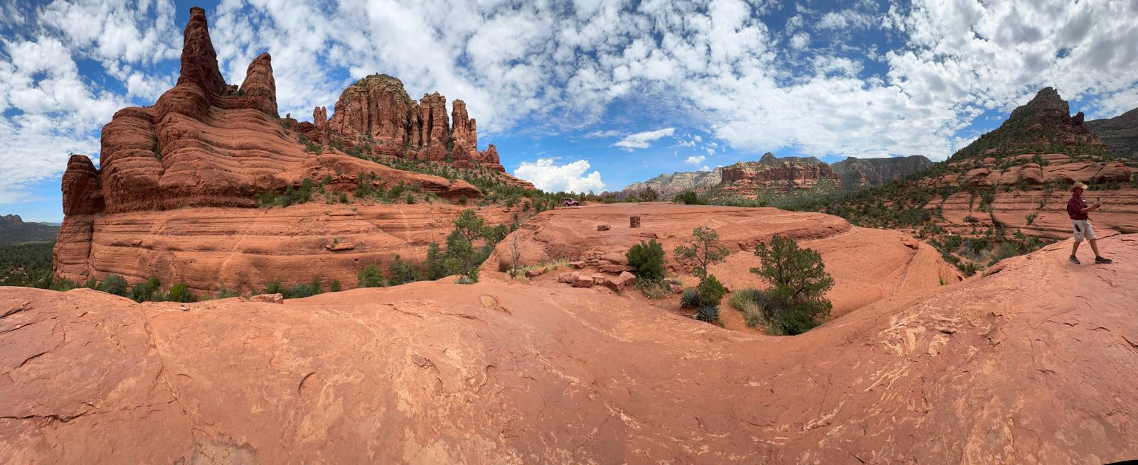 Red slickrock and sandstone formations under a blue sky near Sedona